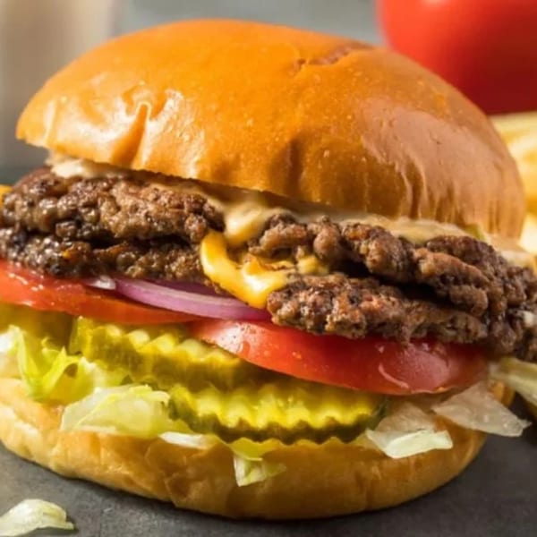 Classic Gourmet Deli's double cheeseburger with lettuce, tomato, red onion, and pickles on a brioche bun.